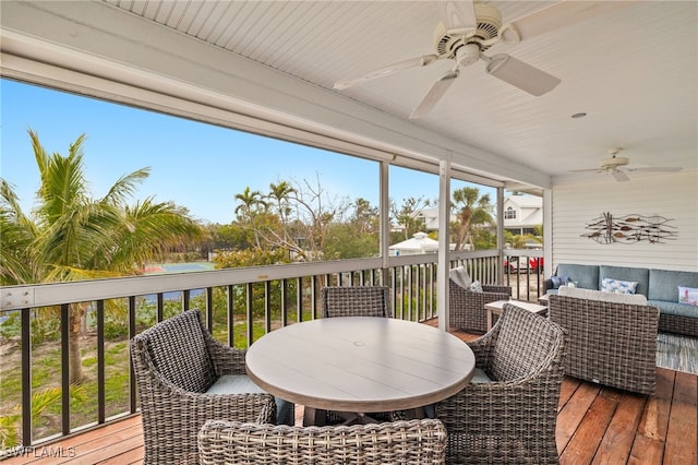 wooden deck featuring an outdoor living space, outdoor dining area, and a ceiling fan