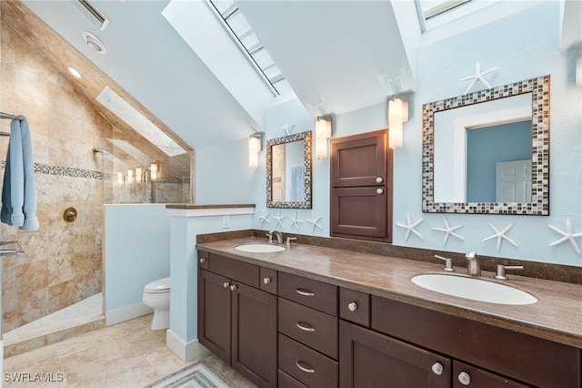 bathroom featuring vaulted ceiling with skylight, a walk in shower, toilet, and a sink