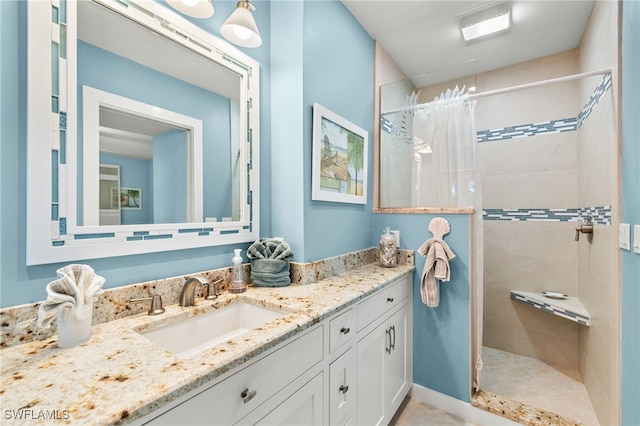 bathroom featuring a tile shower and vanity