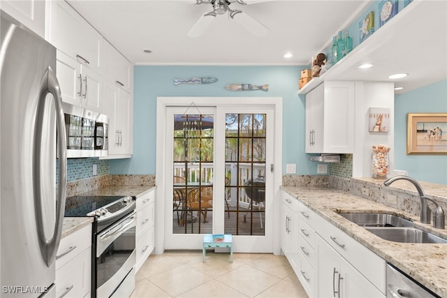 kitchen featuring light tile patterned flooring, white cabinetry, stainless steel appliances, and a sink