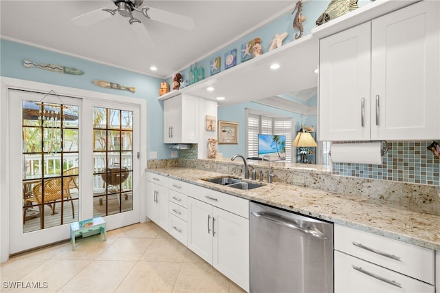 kitchen featuring light tile patterned floors, a sink, a healthy amount of sunlight, and stainless steel dishwasher