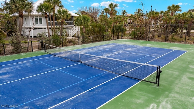 view of tennis court featuring fence