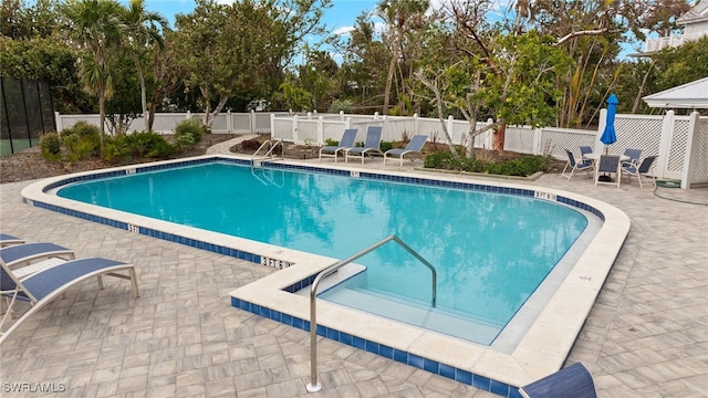 community pool featuring a patio and a fenced backyard