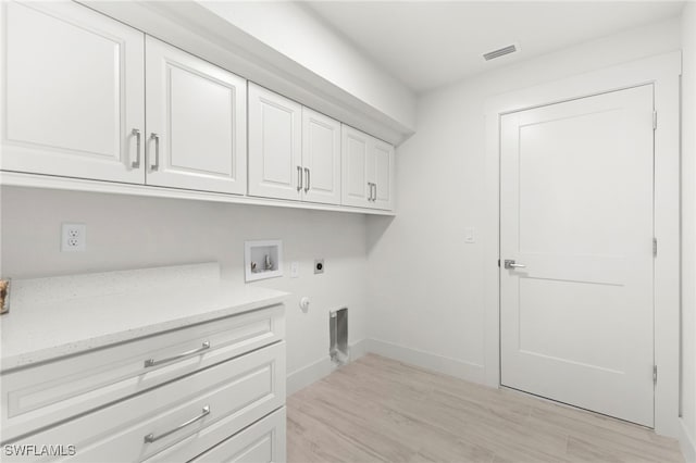 washroom featuring visible vents, hookup for an electric dryer, light wood-style flooring, cabinet space, and washer hookup