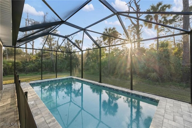 outdoor pool with glass enclosure and a patio