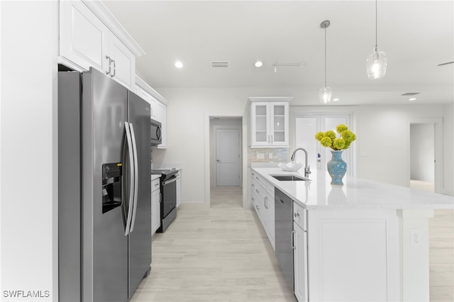 kitchen with visible vents, backsplash, appliances with stainless steel finishes, white cabinets, and a sink