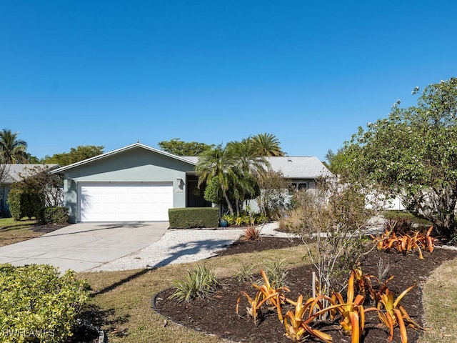 view of front facade with a garage, concrete driveway, and stucco siding