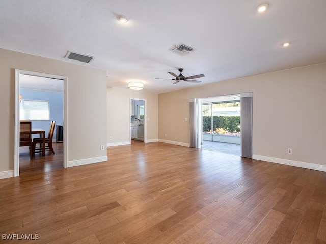 unfurnished room with light wood-style floors, visible vents, and ceiling fan