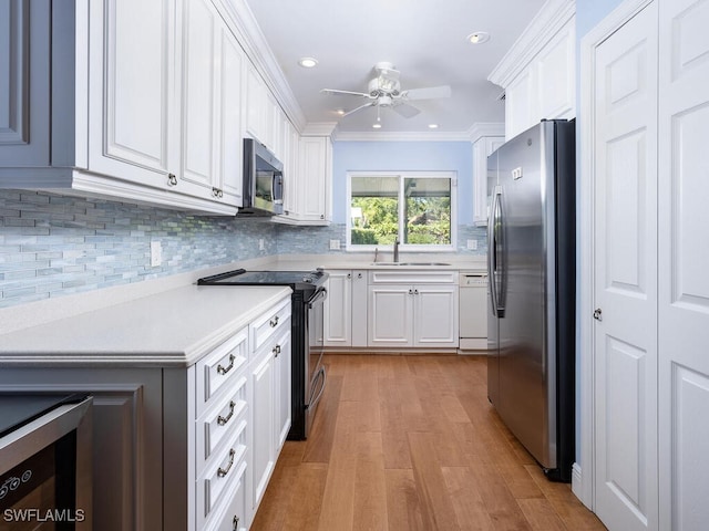 kitchen featuring tasteful backsplash, stainless steel appliances, white cabinets, crown molding, and light countertops