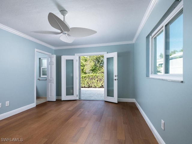 empty room featuring ceiling fan, baseboards, wood finished floors, and crown molding