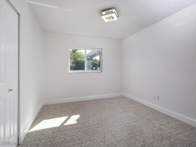 carpeted spare room with baseboards