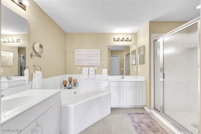 full bath with tile patterned floors, two vanities, a shower stall, and a sink