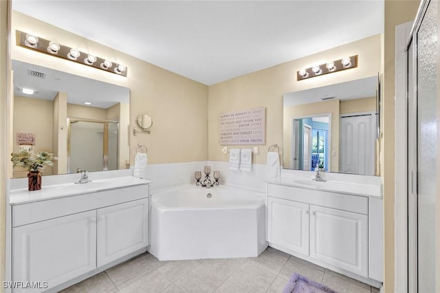 bathroom with a sink, two vanities, a stall shower, and tile patterned floors