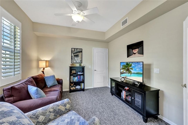 living area with visible vents, a ceiling fan, baseboards, and carpet floors