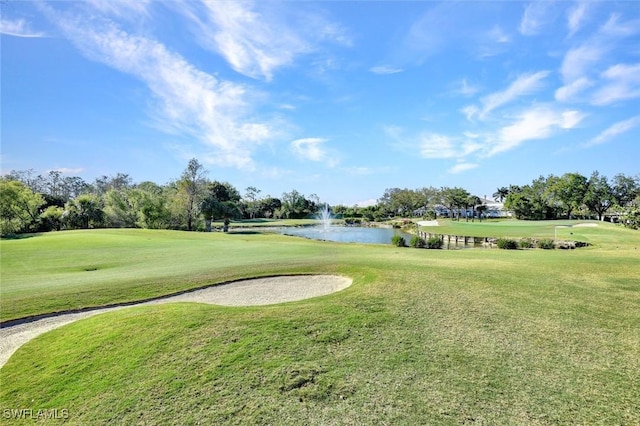 view of property's community featuring golf course view, a water view, and a yard