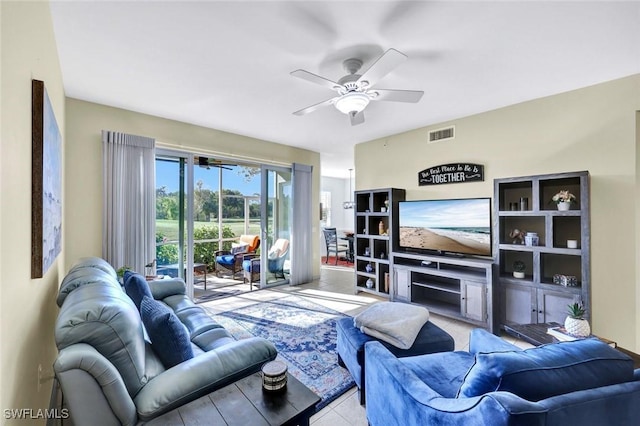 living room with tile patterned flooring, a ceiling fan, visible vents, and a fireplace