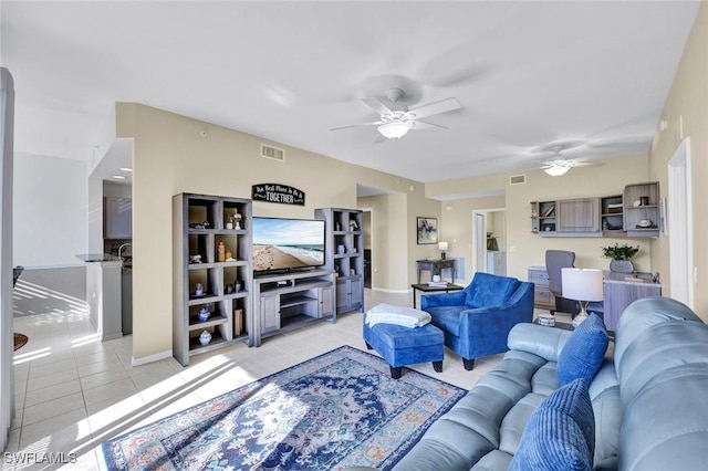 living area featuring light tile patterned floors, baseboards, visible vents, and ceiling fan