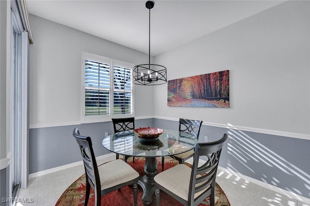 dining area with tile patterned floors, baseboards, and an inviting chandelier