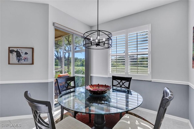 dining space with tile patterned floors, a notable chandelier, and baseboards