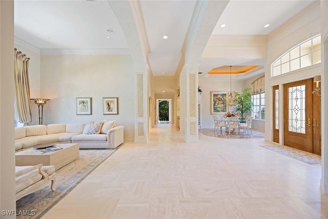 entrance foyer featuring crown molding, decorative columns, recessed lighting, and baseboards