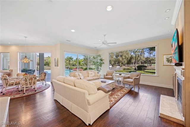 living room with dark wood-style floors, crown molding, baseboards, and a high end fireplace