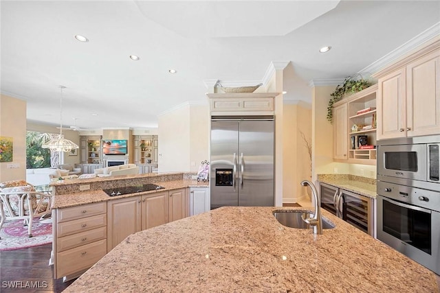 kitchen with a sink, open floor plan, wine cooler, built in appliances, and light stone countertops