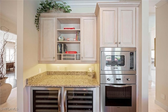 kitchen with crown molding, beverage cooler, light stone counters, cream cabinets, and stainless steel appliances