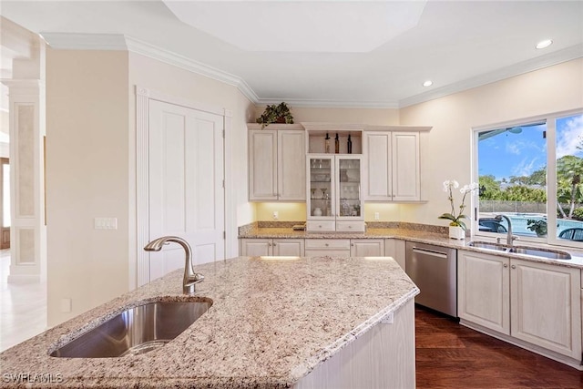 kitchen featuring light stone counters, ornamental molding, stainless steel dishwasher, and a sink