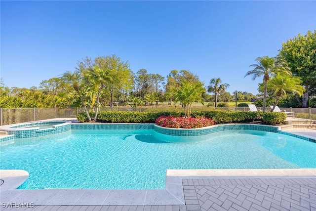 view of pool featuring a patio, a pool with connected hot tub, and fence