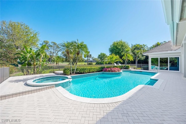 view of swimming pool featuring a patio, fence, and a pool with connected hot tub