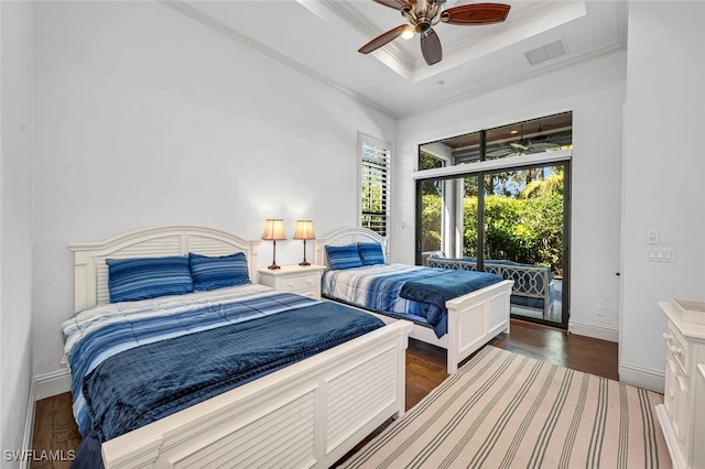 bedroom with visible vents, ornamental molding, access to outside, a tray ceiling, and wood finished floors