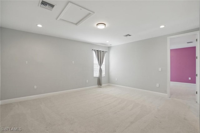 empty room with baseboards, visible vents, light carpet, and attic access