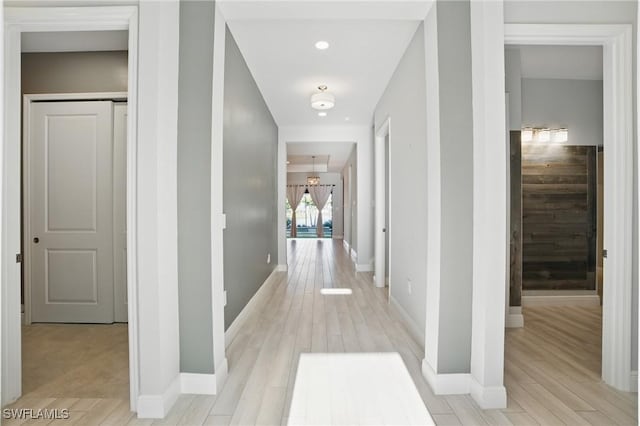 hallway featuring baseboards and light wood-style floors