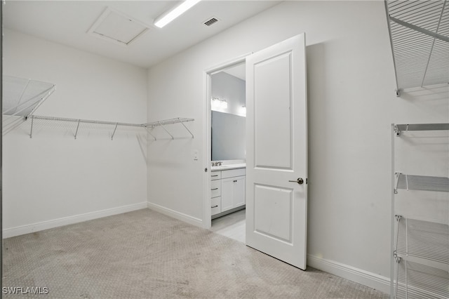 spacious closet with attic access, light colored carpet, and visible vents