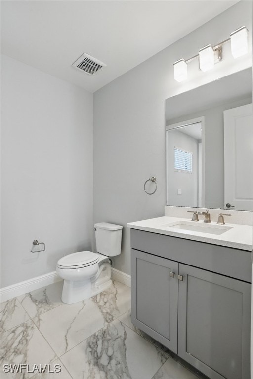 bathroom featuring visible vents, toilet, vanity, and baseboards