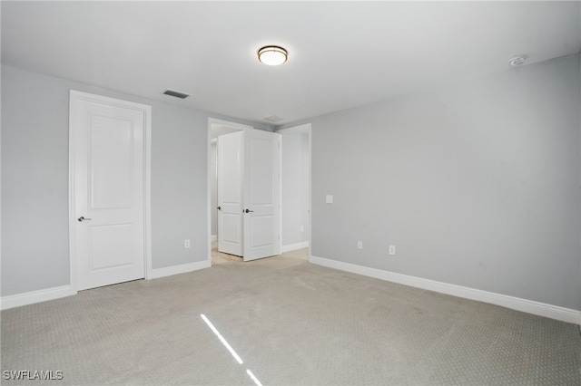 unfurnished bedroom featuring visible vents, light carpet, and baseboards