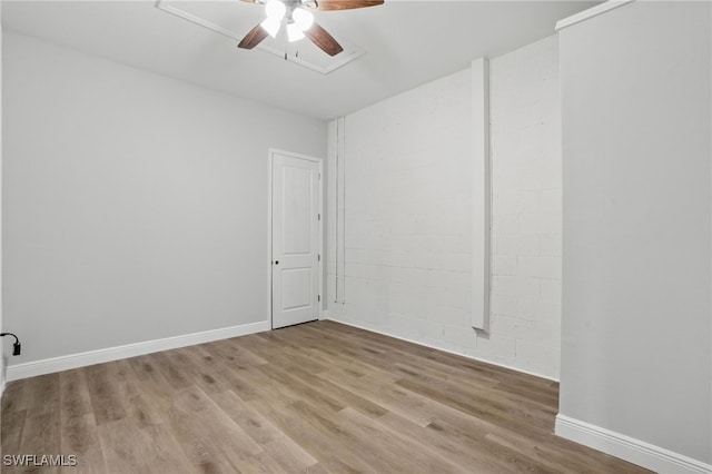 empty room with a ceiling fan, wood finished floors, and baseboards