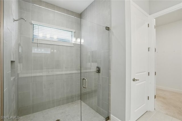 bathroom with tile patterned floors, a shower stall, and baseboards