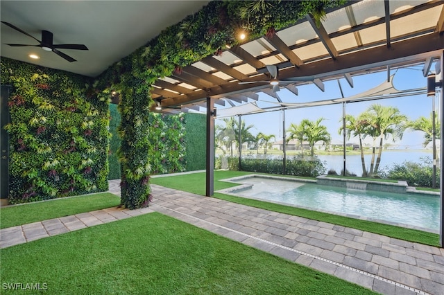 outdoor pool featuring ceiling fan, a water view, a lanai, a lawn, and a patio area