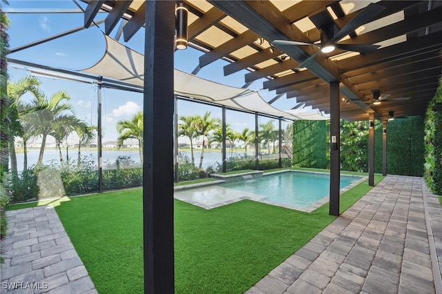 pool with ceiling fan, a water view, a lanai, a yard, and a patio area