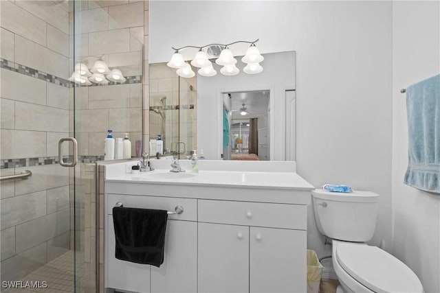 bathroom with vanity, a ceiling fan, a stall shower, ensuite bathroom, and toilet