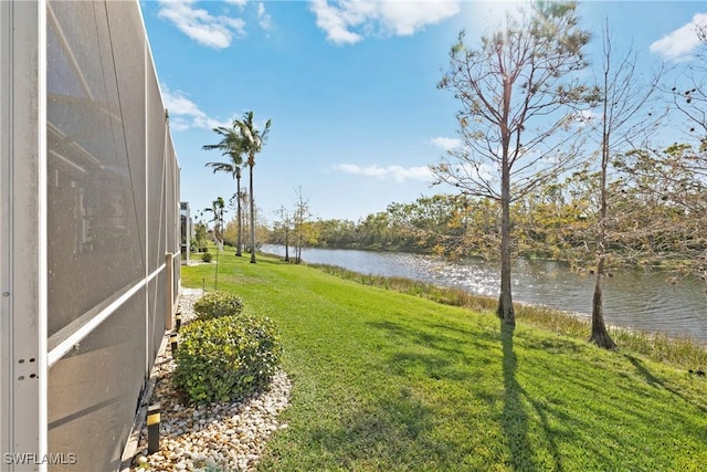 view of yard with a lanai and a water view