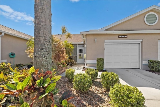 view of front of house with stucco siding, an attached garage, and concrete driveway