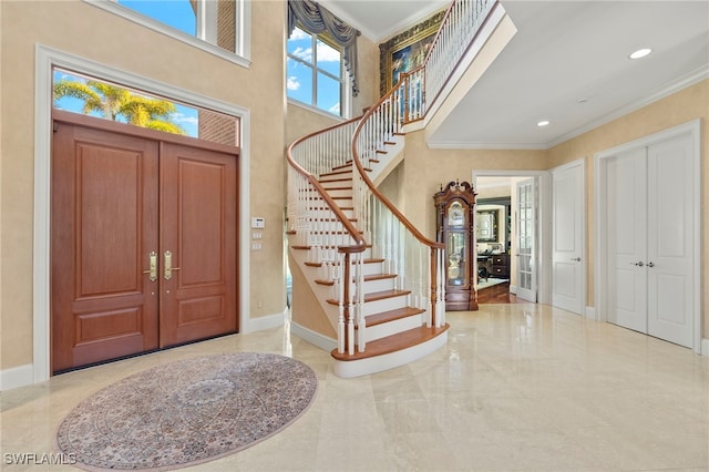 entryway featuring stairway, baseboards, a high ceiling, crown molding, and marble finish floor