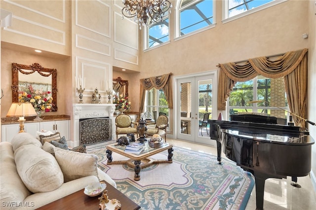 living room featuring french doors, a chandelier, and a fireplace