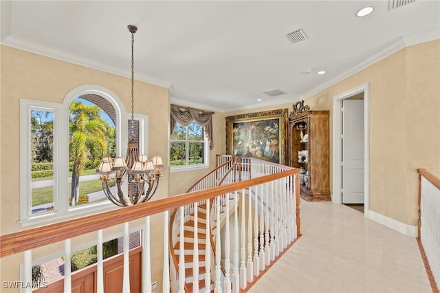 hallway with visible vents, crown molding, baseboards, an upstairs landing, and a notable chandelier