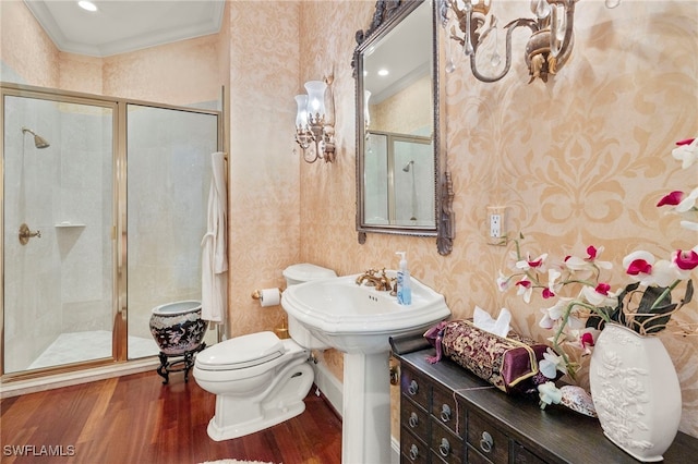 bathroom with toilet, a sink, wood finished floors, a shower stall, and crown molding