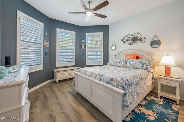 bedroom featuring wood finished floors, baseboards, and ceiling fan