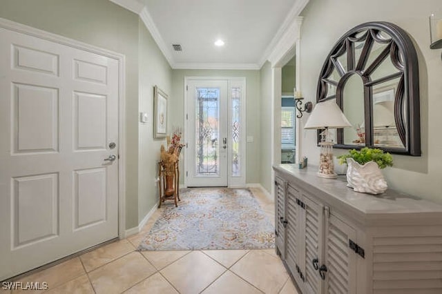 entrance foyer with light tile patterned flooring, baseboards, visible vents, and ornamental molding