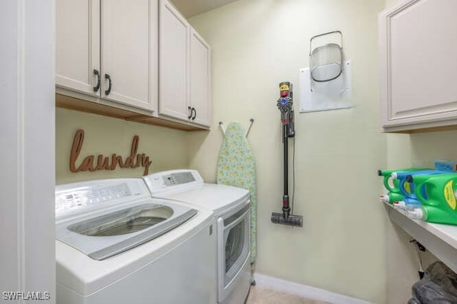 laundry area with cabinet space, washing machine and dryer, and baseboards